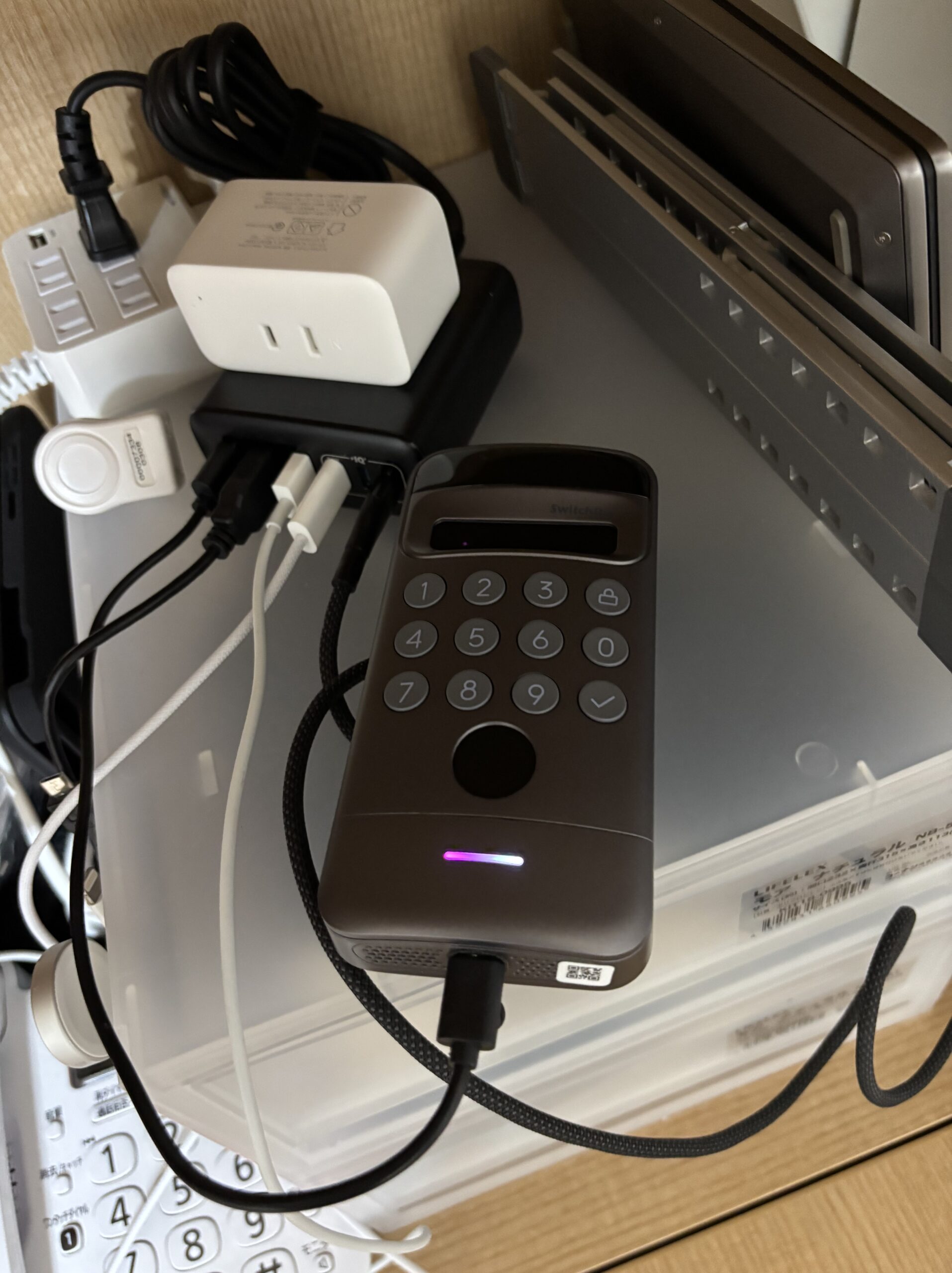 USBケーブルを接続して室内で充電している顔認証パッドPro