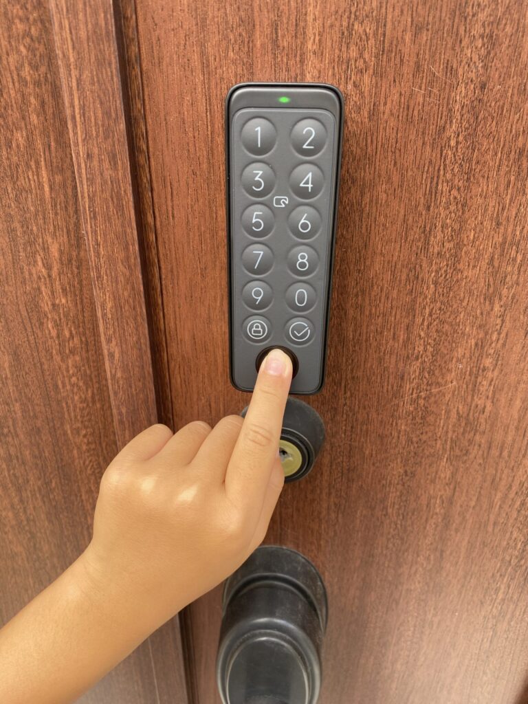 SwitchBot指紋認証パッドを玄関で操作する子ども